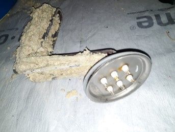 Heizelement mit hellem Kalkbelag, daneben die Flanschplatte